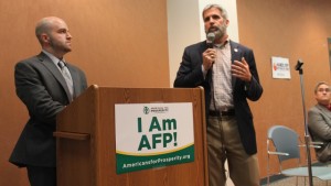 AFP sponsored anti-medicaid expansion event with Delegate Tag Greason and Randy Minchew. The sign behind Greason reads "HANDS OFF MY HEALTH CARE"